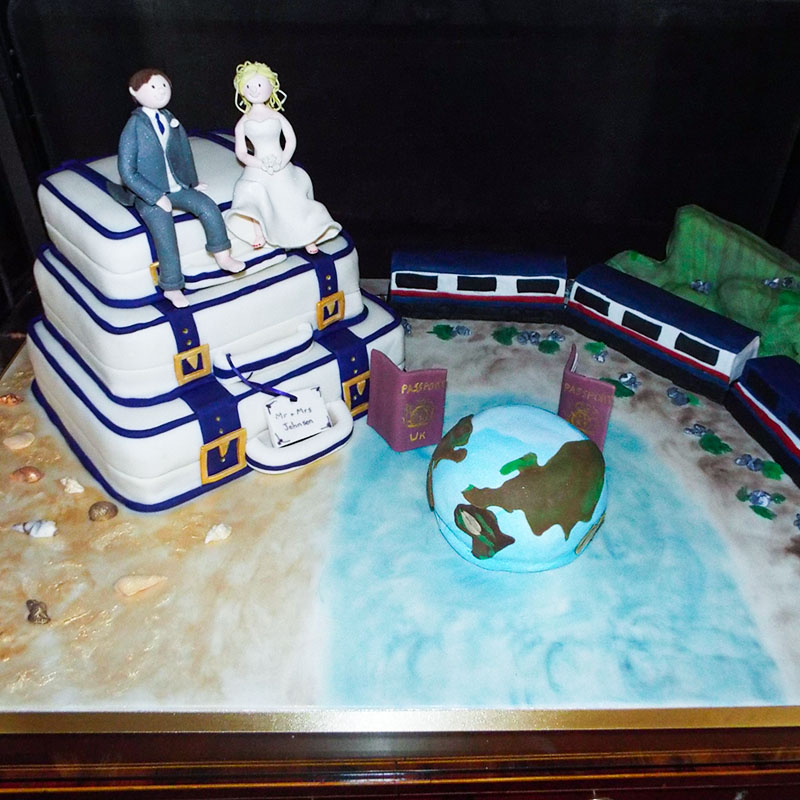 travel theme wedding cake suitcase rocky mountain train globe